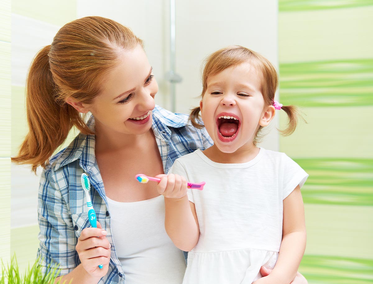 mom and little girl brushing teeth